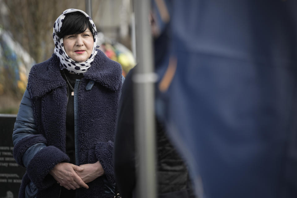 Nataliia Verbova, wife of Andrii Verbovyi, one of eight men killed by Russian forces near a building on Yablunska street, visits her husband's grave in Bucha, Ukraine, Tuesday, March 26, 2024. Days after Russian forces withdrew from the area in late March, in the dramatic first weeks of the full-scale invasion, a photo taken by AP Photographer Vadim Ghirda revealed what happened to the eight men. (AP Photo/Enric Marti)