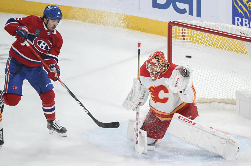 Montreal Canadiens' Alex Newhook, left, moves in on Calgary Flames goaltender Jacob Markstrom during the second period of an NHL hockey match in Montreal, Quebec, Tuesday, Nov. 14, 2023. (Graham Hughes/The Canadian Press via AP)