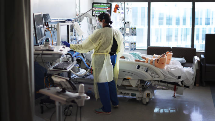 A respiratory therapist helps a COVID patient in the ICU at Rush University Medical Center in Chicago.