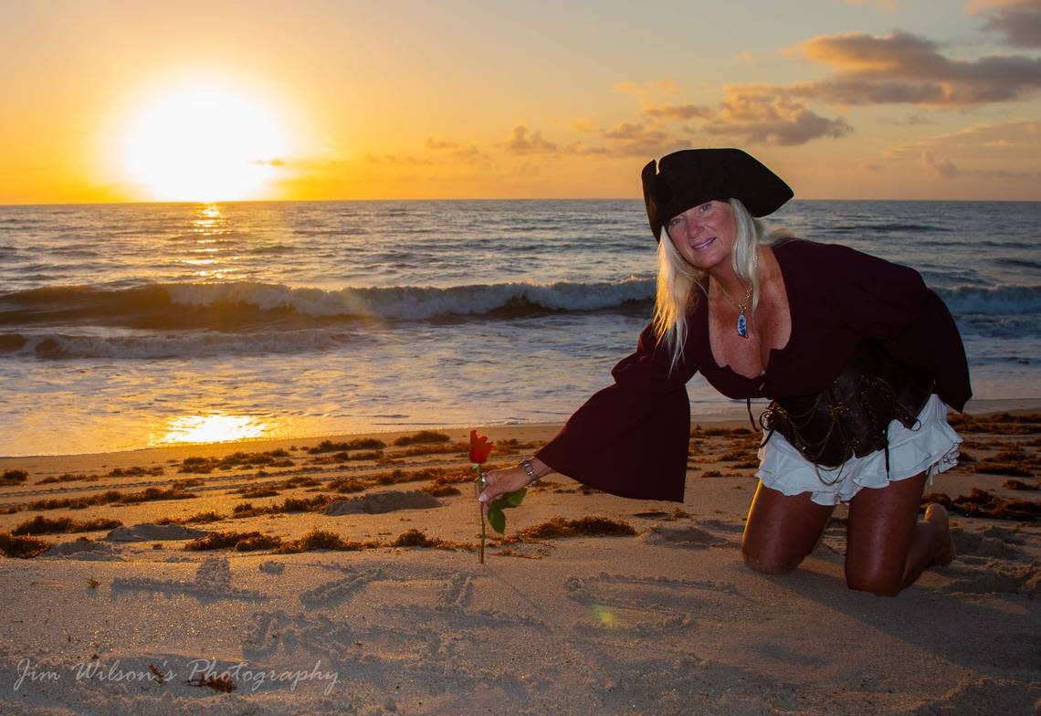 Candi Lynn Nichols, who goes by “Cutlass Candi” and identifies as a pirate, plants a rose in the sand on a Florida beach in honor of of the sailors who died when the 1715 Treasure Fleet sank and gave the Treasure Coast its name. 