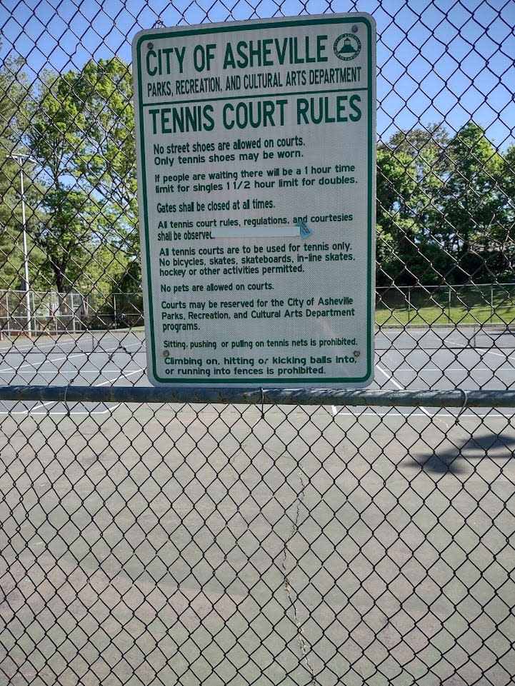 This sign hangs outside the Weaver Park tennis courts, but there is no sign at Montford Park courts.