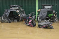 A dog stays on a tricycle to keep dry along a flooded road due to Typhoon Noru in San Miguel town, Bulacan province, Philippines, Monday, Sept. 26, 2022. Typhoon Noru blew out of the northern Philippines on Monday, leaving some people dead, causing floods and power outages and forcing officials to suspend classes and government work in the capital and outlying provinces. (AP Photo/Aaron Favila)