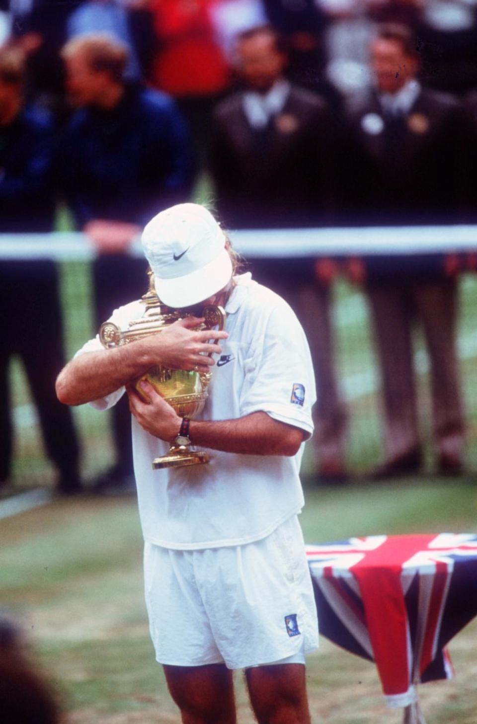 PHOTO: Tennis Player Andre Agassi hugs his trophy after winning at Wimbledon on July 5, 1992 In England. (John Russell/Getty Images, FILE)