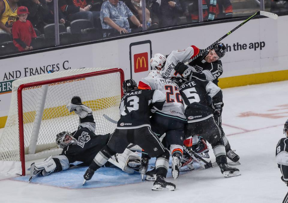 The Coachella Valley Firebirds and the Ontario Reign fight for the puck in front of the net at Acrisure Arena in Palm Desert, Calif., Oct. 25, 2023.