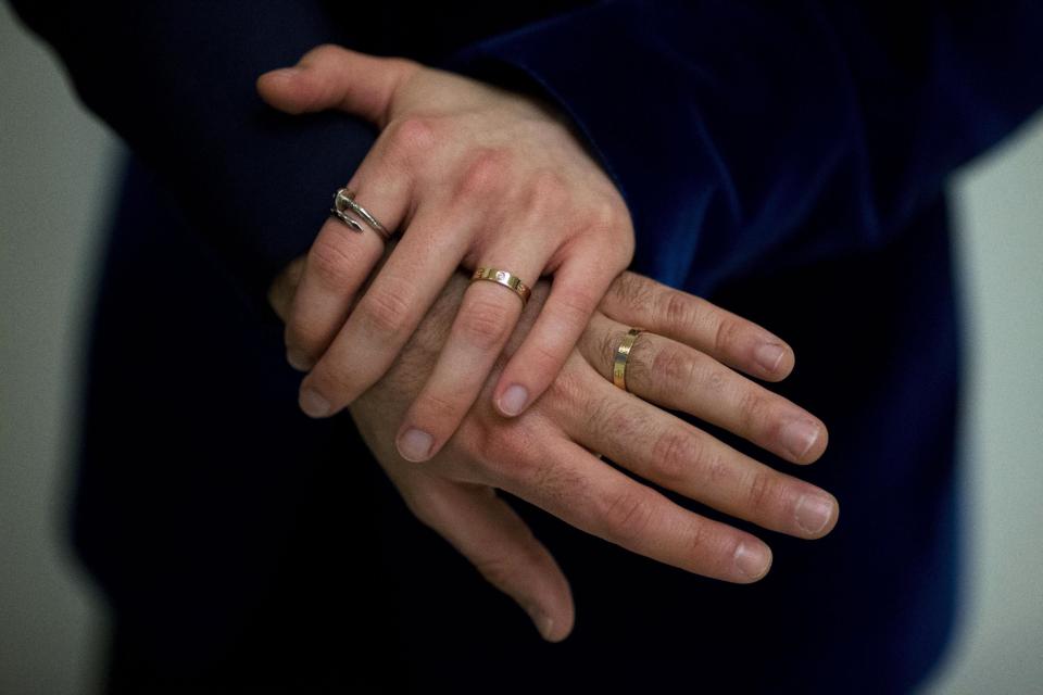 The wedding rings of Sean Adl-Tabatabai and Sinclair Treadway are seen on their fingers as they pose for photographs after they were officially married in a wedding ceremony in the Council Chamber at Camden Town Hall in London, minutes into Saturday, March 29, 2014. Gay couples in Britain waited decades for the right to get married. When the opportunity came, some had just days to plan the biggest moment of their lives. Adl-Tabatabai, a 32-year-old TV producer from London, and Treadway, a 20-year-old student originally from Los Angeles, registered their intent to marry on March 13, the first day gay couples could sign up for wedding ceremonies under Britain's new law. Eager to be part of history, the two men picked the earliest possible moment - just after midnight Friday, when the act legalizing same-sex marriage takes effect. (AP Photo/Matt Dunham)
