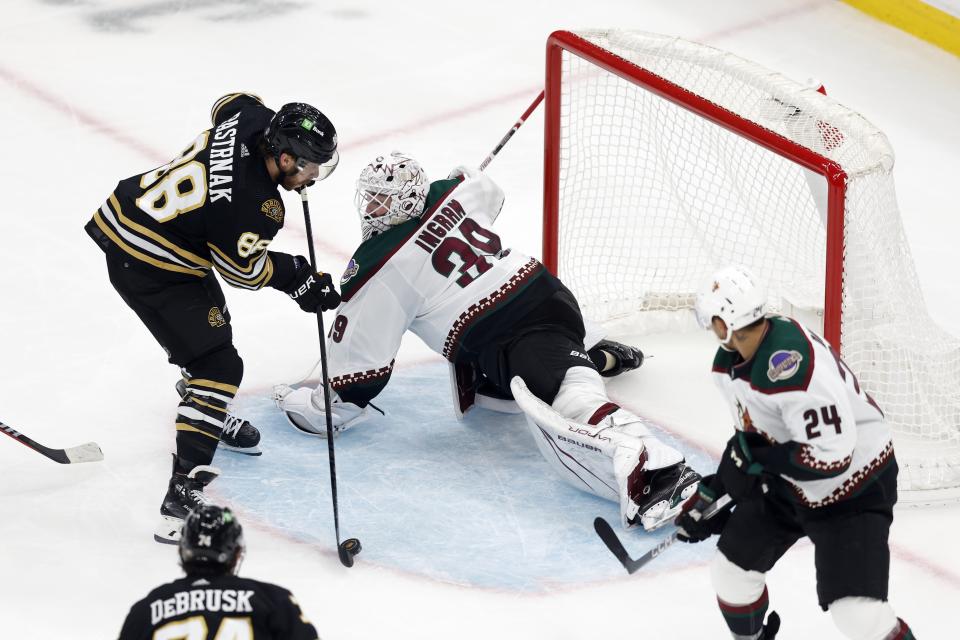 Boston Bruins' David Pastrnak (88) scores on Arizona Coyotes' Connor Ingram (39) during the third period of an NHL hockey game, Saturday, Dec. 9 2023, in Boston. (AP Photo/Michael Dwyer)