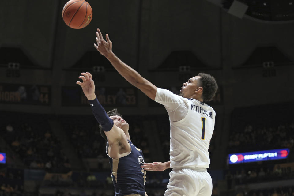 West Virginia forward Emmitt Matthews Jr. (1) shoots past Mount St. Mary's forward George Tinsley (11) during the second half of an NCAA college basketball game in Morgantown, W.Va., Monday, Nov. 7, 2022. (AP Photo/Kathleen Batten)