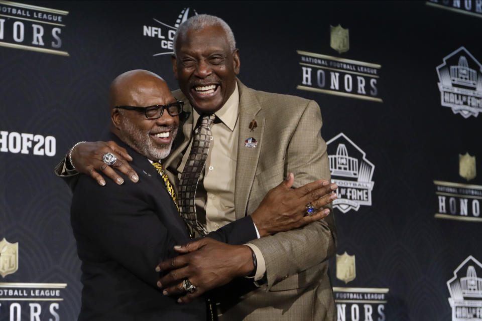 FILE - Hall of Fame Class of 2020 Donnie Shell, left, hugs Harold Carmichael at the NFL Honors football award show in Miami, in this Saturday, Feb. 1, 2020, file photo. Built more like an NBA player at 6-foot-8, Harold Carmichael turned to football because he couldn’t perform basketball’s most basic skill. Carmichael couldn't dribble. It worked out for the best. Carmichael used his size to outjump and overpower defenders, catching more passes for more yards and touchdowns than any player in the history of the Philadelphia Eagles. The gentle giant then waited patiently for three decades before he was elected to the Pro Football Hall of Fame as part of last year’s special centennial class. (AP Photo/Mark Humphrey, File)