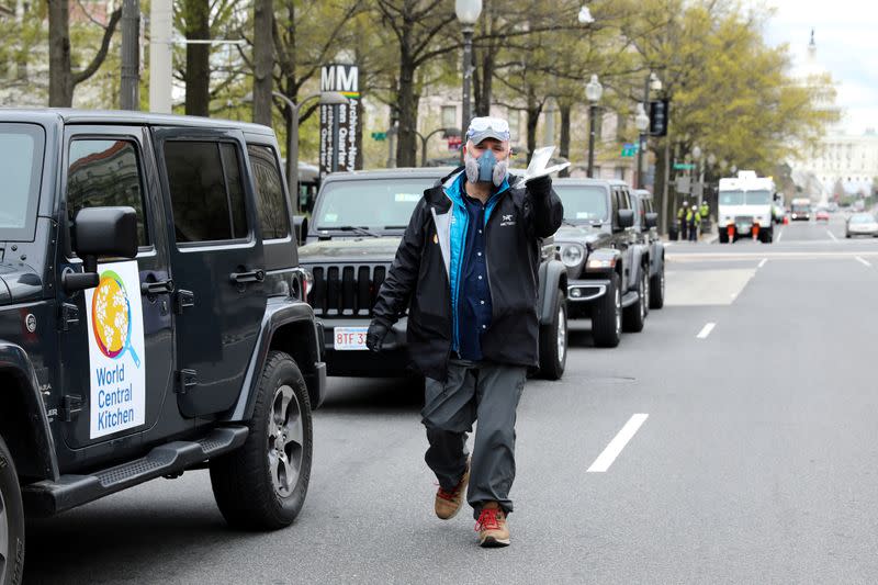 FILE PHOTO: Andres offers a pair of masks to a reporter as he prepares with members of his World Central Kitchen team to load meals to deliver to people in need during the coronavirus outbreak in downtown Washington