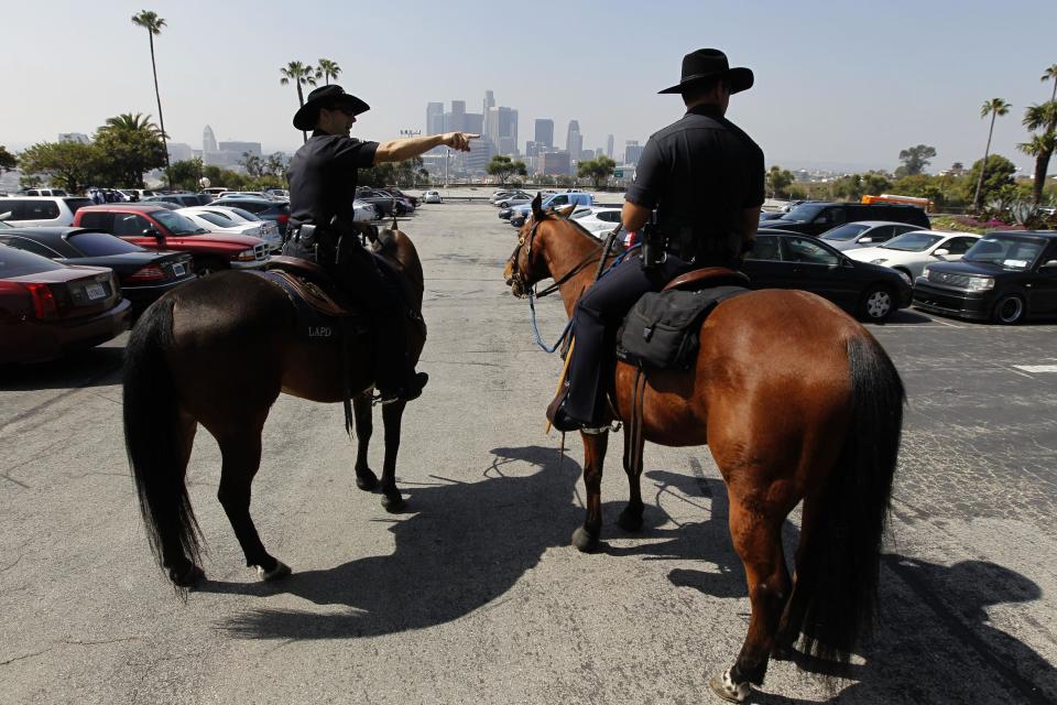 Members of the Los Angeles Police Department's mounted patrol work the parking lot before a baseball game between the Los Angeles Dodgers and the Pittsburgh Pirates in Los Angeles, Tuesday, April 10, 2012. Police were out in force for opening day at Dodger Stadium, swarming on bikes, going undercover and looking for boozing tailgaters a year after a Giants fan was beaten into a coma in the parking lot.(AP Photo/Chris Carlson)