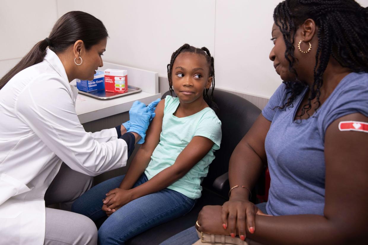 CVS pharmacist performs immunization on young child amidst high rates of Influenza, COVID-19 and RSV nationally