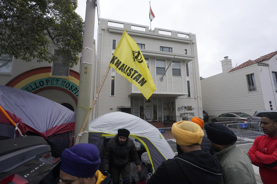 Protesters stand outside of the entrance to the Consulate General of India in San Francisco, Monday, March 20, 2023. San Francisco police had erected barriers and parked a vehicle nearby as people protested outside the Consulate General of India to protest the capture of Amritpal Singh. (AP Photo/Jeff Chiu)