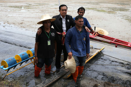 Thailand's Prime Minister Prayuth Chan-ocha poses with farmer at a farmer school in Suphan Buri province, Thailand, September 18, 2017. Picture taken September 18, 2017. REUTERS/Athit Perawongmetha