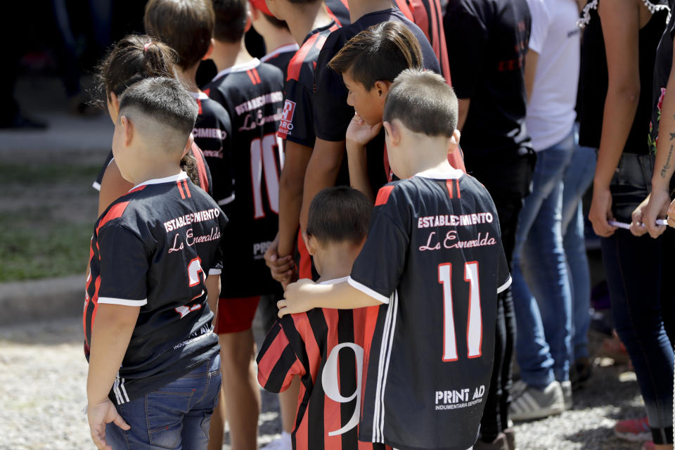 Children wait for soccer player Emiliano Sala's coffin to depart for Santa Fe, after his wake in Progreso, Argentina, Saturday, Feb. 16, 2019. The Argentina-born forward died in an airplane crash in the English Channel last month when flying from Nantes in France to start his new career with English Premier League club Cardiff. (AP Photo/Natacha Pisarenko)