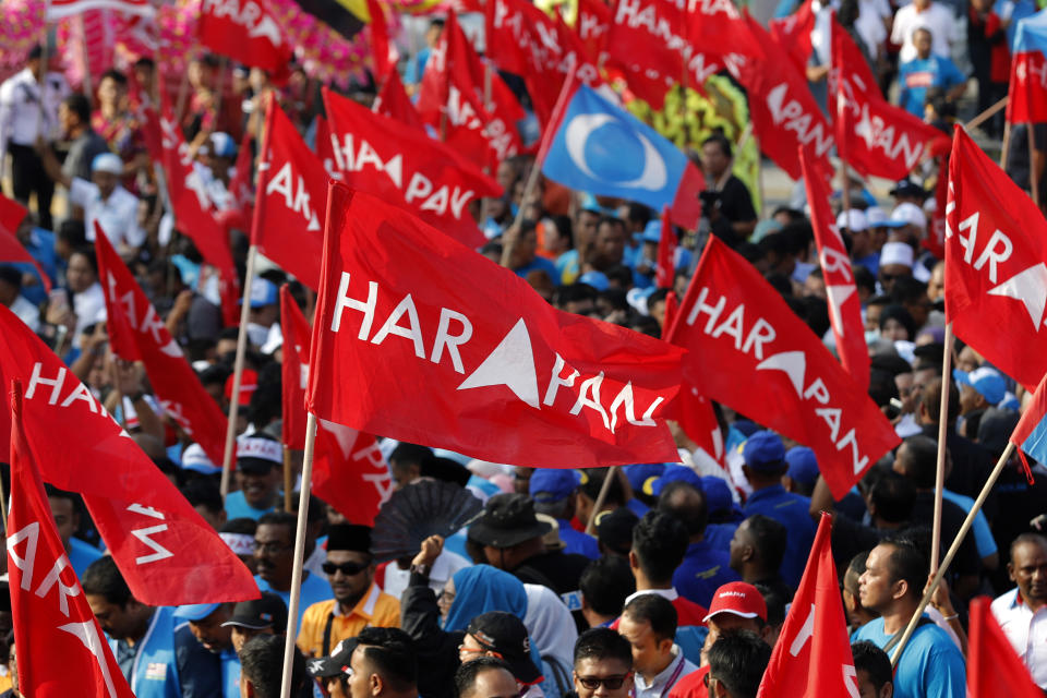 Supporters wave flags of Pakatan Harapan (Alliance of Hope) as Anwar Ibrahim arrives for by-election nomination in Port Dickson, Malaysia, Saturday, Sept. 29, 2018. Anwar will contest the Oct. 13 by-election in Port Dickson, a southern coastal town after a lawmaker vacated the seat to make way for Anwar Ibrahim's political comeback. (AP Photo/Vincent Thian)