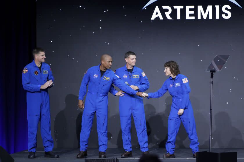 From left, Jeremy Hansen, Victor Glover, Reid Wiseman and Christina Hammock Koch, celebrate on stage as they are announced as the Artemis II crew during a NASA ceremony naming the four astronauts who will fly around the moon by the end of next year, at a ceremony held in the NASA hangar at Ellington airport Monday, April 3, 2023, in Houston. (AP Photo/Michael Wyke)