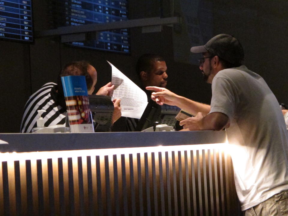 This Sept. 5, 2019 photo shows a gambler making a sports bet at Bally's casino in Atlantic City N.J. Participants in a national sports betting conference on Dec. 1, 2020, agreed that huge holes in state budgets due to the coronavirus outbreak, and the demonstrated eagerness of fans to bet on sports are likely to spur a further expansion of sports betting and online casino gambling in the U.S. (AP Photo/Wayne Parry)