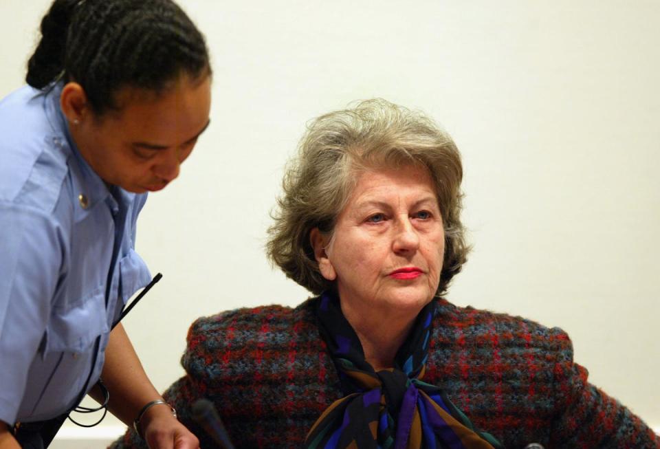 A court officer stands next to Biljana Plavšić during her trial at the Hague.