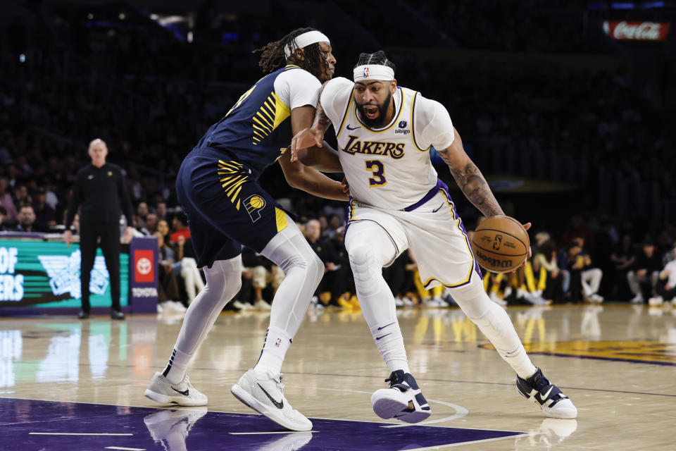 Los Angeles Lakers forward-center Anthony Davis (3) dribbles past Indiana Pacers center-forward Myles Turner during the first half of an NBA basketball game, Sunday, March 24, 2024, in Los Angeles. (AP Photo/Etienne Laurent)