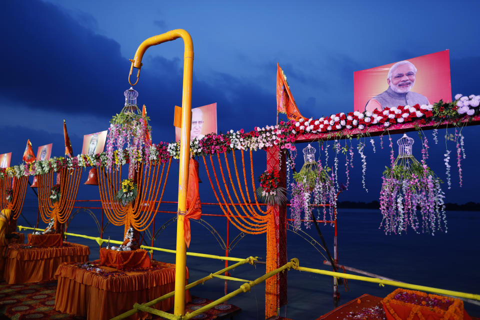 A photo of Indian Prime Minister Narendra Modi, right, along with other leaders are seen on the decorated ghats of the Saryu river ahead of a groundbreaking ceremony of a temple to the Hindu god Ram in Ayodhya, in the Indian state of Uttar Pradesh, Monday, Aug. 3, 2020. As Hindus prepare to celebrate the groundbreaking of a long-awaited temple at a disputed ground in northern India, Muslims say they have no firm plans yet to build a new mosque at an alternative site they were granted to replace the one torn down by Hindu hard-liners decades ago. (AP Photo/Rajesh Kumar Singh)