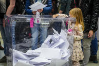 A little girl places a ballot in the box during parliamentary elections in Warsaw, Poland, Sunday, Oct. 15, 2023. The outcome of Sunday's election will determine whether the right-wing Law and Justice party will win an unprecedented third straight term or whether a combined opposition can win enough support to oust it. (AP Photo/Petr David Josek)