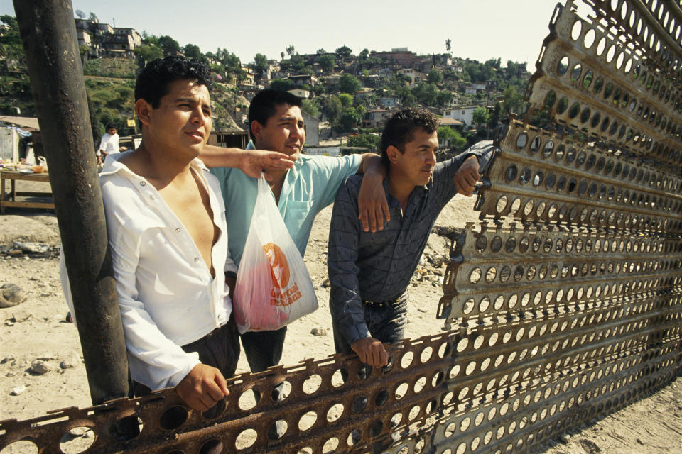 Men look across to the other side of the Tijuana border.