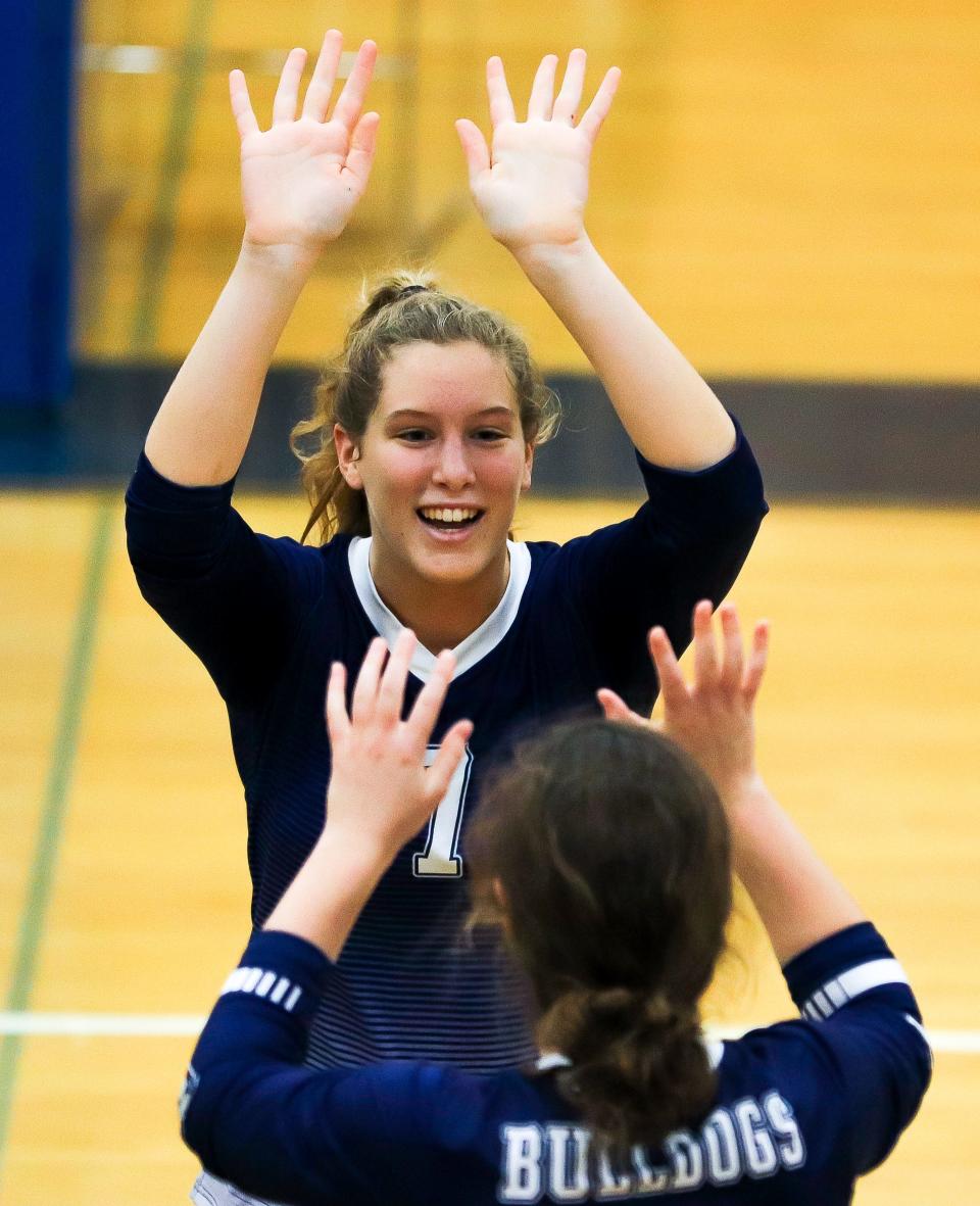 Rockland's Maggie Elie high-fives a teammate during a game against Norwell on Thursday, September 29, 2022. Rockland won in five sets (25-18, 21-25, 21-25, 25-21, 16-14).