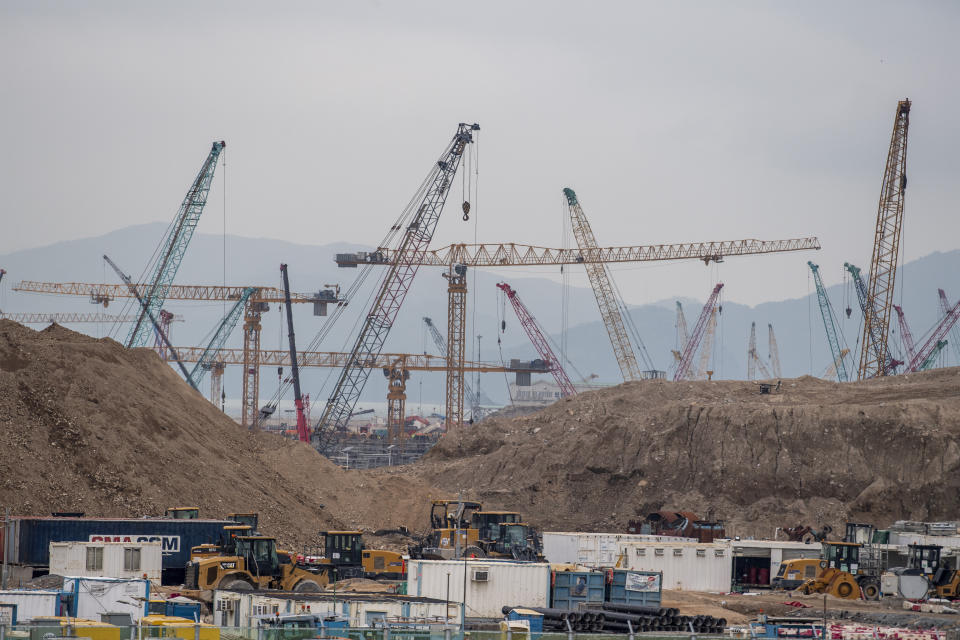 Construction cranes are seen near the new third runway at Hong Kong International Airport in Hong Kong, Friday, Nov. 25, 2022. Hong Kong on Friday launched its newly-built third runway, which is expected to be part of a three-runway system in 2024 that will boost the city's status as an aviation hub. (AP Photo/Vernon Yuen)