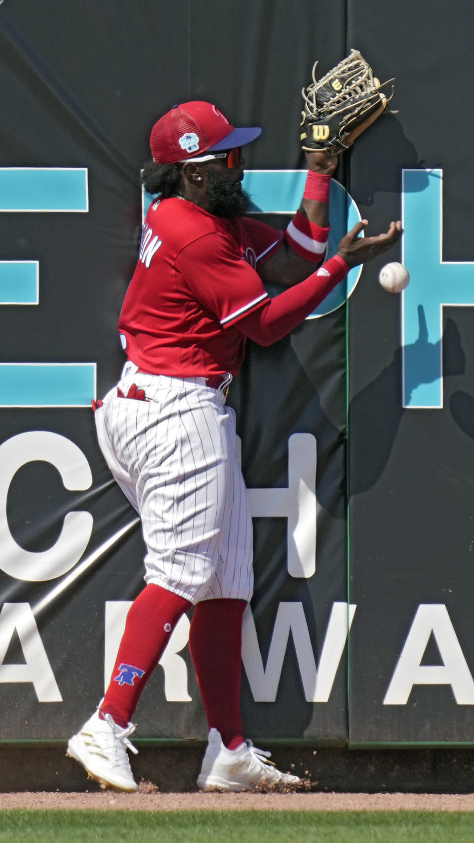 Philadelphia Phillies left fielder Josh Harrison (2) drops a double by Tampa Bay Rays' Curtis Mead during the fifth inning of a spring training baseball game Tuesday, March 7, 2023, in Clearwater, Fla. (AP Photo/Chris O'Meara)