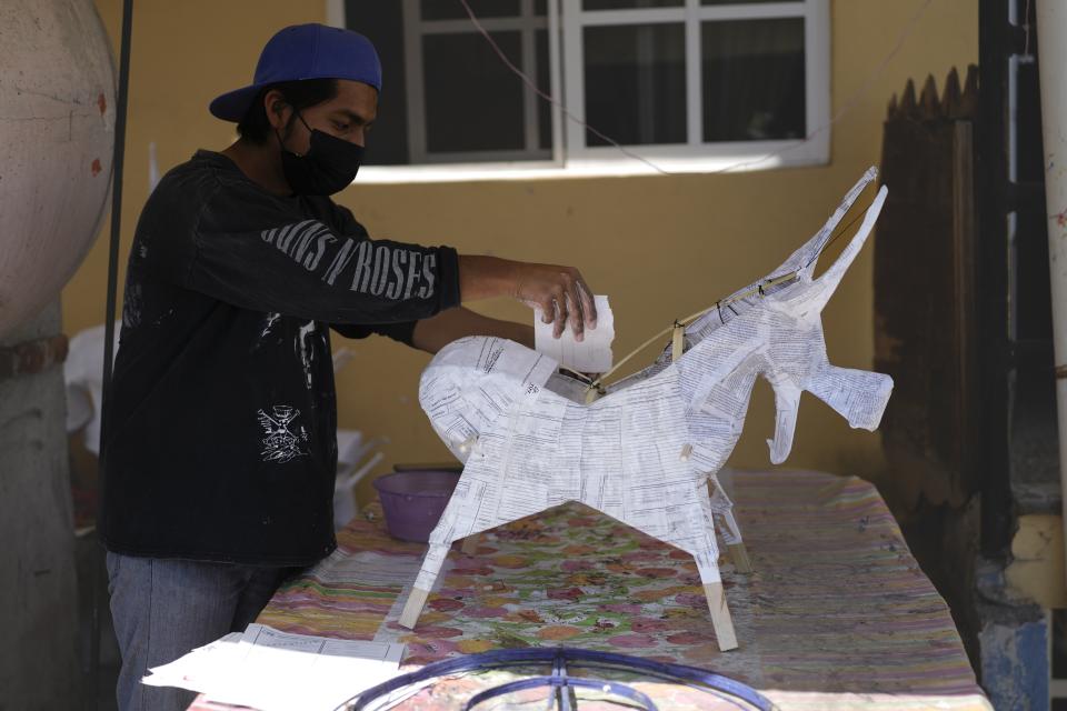 Edward Martínez hace un toro de papel maché para que sea rellenado con fuegos artificiales en el taller de su familia previo al festival anual en honor a San Juan de Dios, el santo patrono de los pobres y enfermos, en Tultepec, México, el martes 5 de marzo de 2024. (AP Foto/Marco Ugarte)