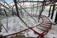 SEASIDE HEIGHTS, NJ - NOVEMBER 16: Waves break at a destroyed roller coaster from the Funtime Pier on November 16, 2012 in Seaside Heights, New Jersey. Two amusement piers and a number of roller coasters in the seaside town were destroyed by Superstorm Sandy. (Photo by Mario Tama/Getty Images)