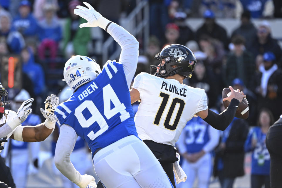 UCF quarterback John Rhys Plumlee (10) throws the ball while being pressured by Duke defensive end R.J. Oben (94) during the first half of the Military Bowl NCAA college football game, Wednesday, Dec. 28, 2022, in Annapolis, Md. (AP Photo/Terrance Williams)