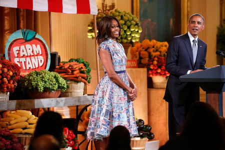 U.S. first lady Michelle Obama (C) and President Barack Obama confess that their favorite junk foods are french fries (her) and chips and guacamole (him) as they play host to a Kids State Dinner for children who won a healthy-foods recipe contest, at the White House in Washington July 18, 2014. REUTERS/Jonathan Ernst/File Photo