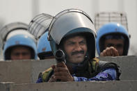 Rapid Action Force personnel guard a major highway at Singhu near New Delhi to stop thousands of protesting farmers from entering the capital, India, Tuesday, Feb.13, 2024. Farmers, who began their march from northern Haryana and Punjab states, are asking for a guaranteed minimum support price for all farm produce. (AP Photo/Manish Swarup)