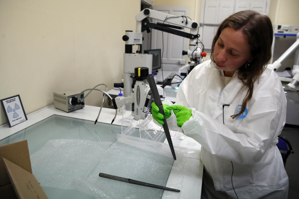 In this photo taken on Wednesday, Oct. 9, 2019, Metals chief Aurelia Azema displays traces on the metal pipes of the Notre Dame cathedral organ to measure a kind of lead "fingerprint" at Champs-sur-Marne, west of Paris. Scientists at the French government's Historical Monuments Research Laboratory are using these objects as clues in an urgent and vital task, working out how to safely restore the beloved Paris cathedral and identify what perils remain inside in a race against the clock. (AP Photo/Francois Mori)