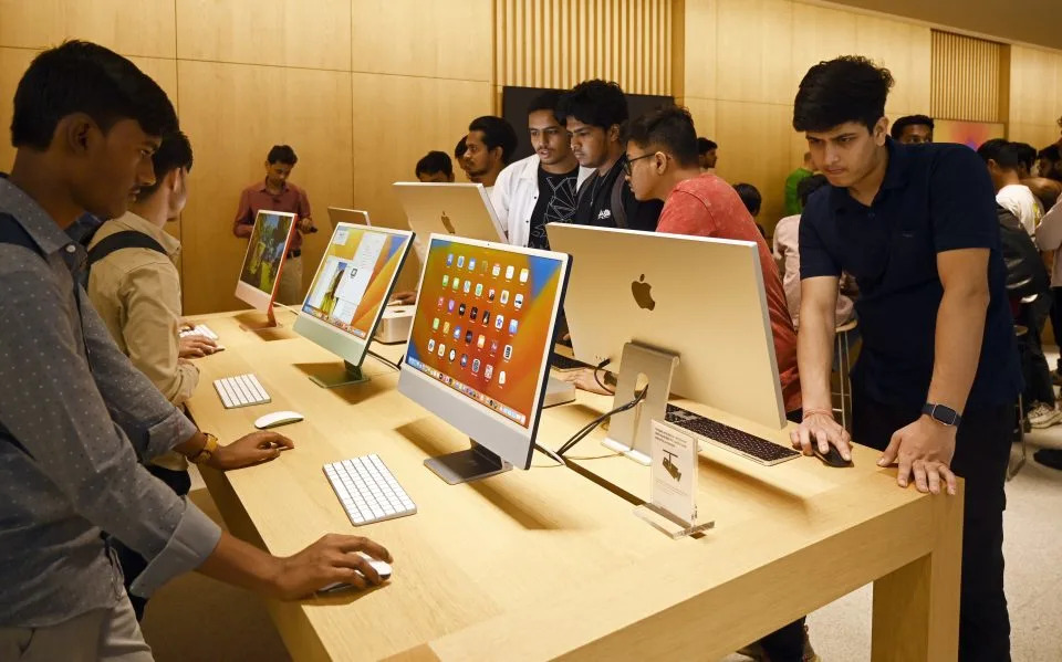 People playing on Apple's iMac desktop screens.