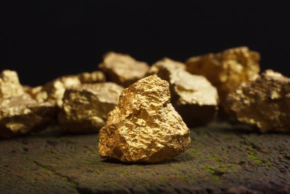 Gold nuggets sitting on the ground.