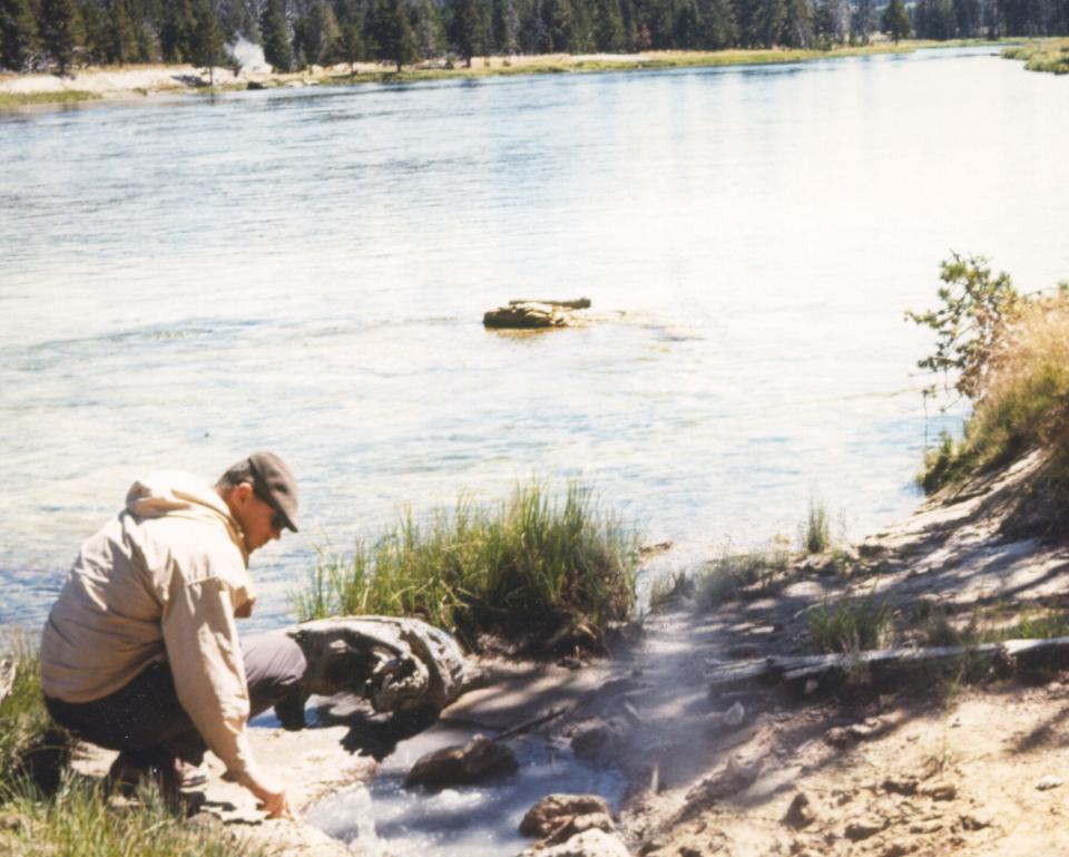 Microbiologist Tom Brock collects one of his first samples from the Yellowstone River in 1964. A pioneer in his field, Brock's discovery of bacteria that can live in extremely high temperatures led to major advancements in biology and medicine, including the technology that is used in COVID-19 PCR tests.