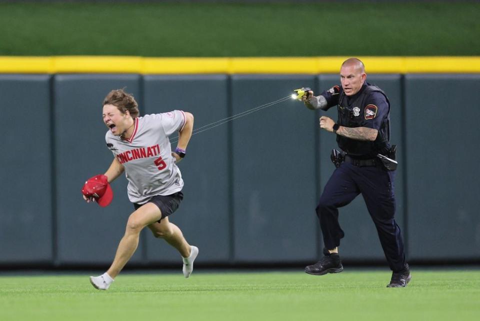 CINCINNATI, OHIO - JUNE 11:  An unidentified fan is tased by a police officer as he runs on the field before the ninth inning of the Cincinnati Reds against Cleveland Guardians at Great American Ball Park on June 11, 2024 in Cincinnati, Ohio. (Photo by Andy Lyons/Getty Images)