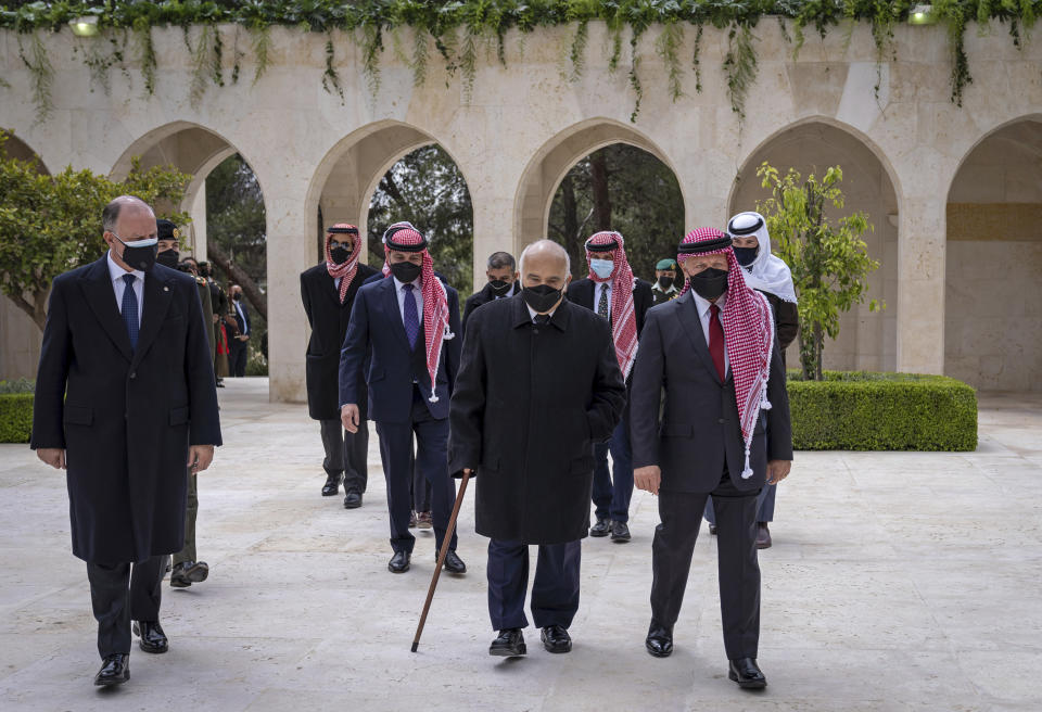 This photo from the Royal Court twitter account, shows Jordan’s King Abdullah II, second right, Prince Hamzah bin Al Hussein, fourth right in blue mask, Prince Hassan bin Talal, fifth right, and others arriving to visit the tombs of former kings, in Amman, Jordan, Sunday, April 11, 2021. King Abdullah II and his half brother Prince Hamzah have made their first joint public appearance since a palace feud last week. Members of the Jordanian royal family Sunday marked the centenary of the establishment of the Emirate of Transjordan, a British protectorate that preceded the kingdom. (Royal Court Twitter Account via AP)