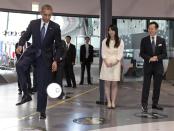 President Barack Obama kicks a ball passed to him by a robot namesd ASIMO, an acronym for Advanced Step in Innovative Mobility, as he attends a youth science event at the National Museum of Emerging Science and Innovation, known as the Miraikan, in Tokyo, Thursday, April 24, 2014. At right is Japanese astronaut Mamoru Mohri, and director of the Museum. (AP Photo/Carolyn Kaster)