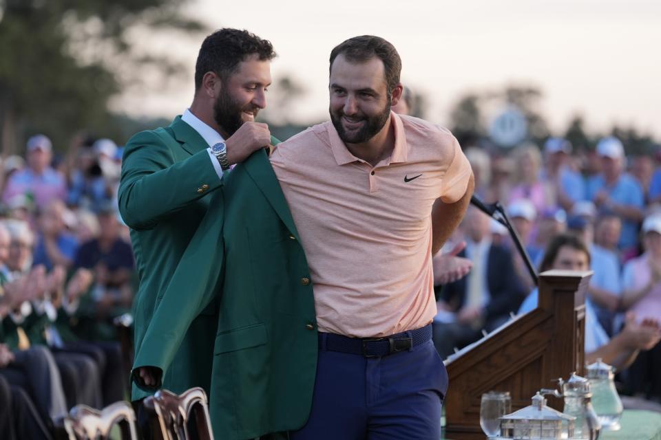 Spain's Jon Rahm puts on the green jacket for winner Scottie Scheffler after the Masters Golf Tournament at Augusta National Golf Club in Augusta, Georgia, Sunday, April 14, 2024. (AP Photo/Ashley Landis) )