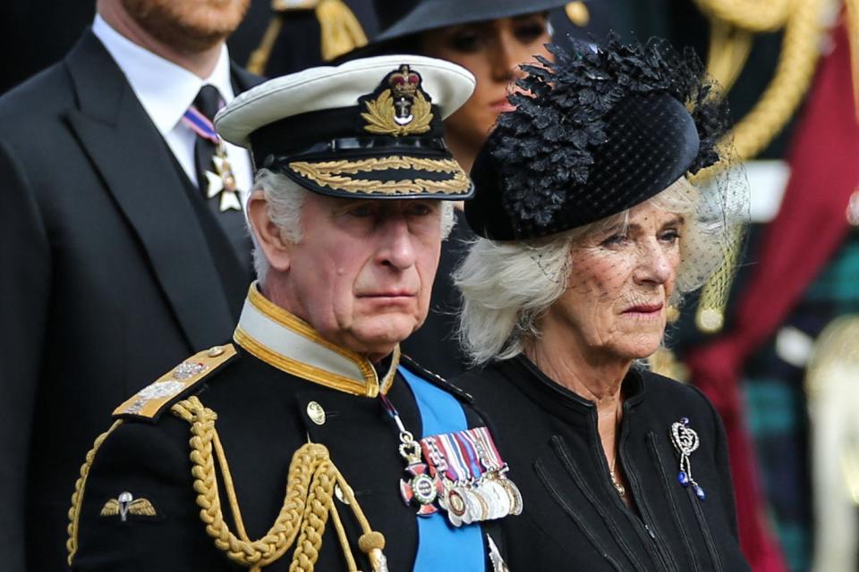King Charles III and Camilla, Queen Consort look at members of the Bearer Party transferring the coffin of Queen Elizabeth II, draped in the Royal Standard, form the State Gun Carriage of the Royal Navy into the State Hearse at Wellington Arch in London on September 19, 2022, after the State Funeral Service of Britain's Queen Elizabeth II.