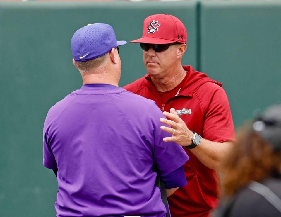 South Carolina coach Mark Kingston shakes hands with James Madison coach Marlin Ikenberry after Sunday’s NCAA Tournament baseball game in Raleigh. JMU won 2-0.