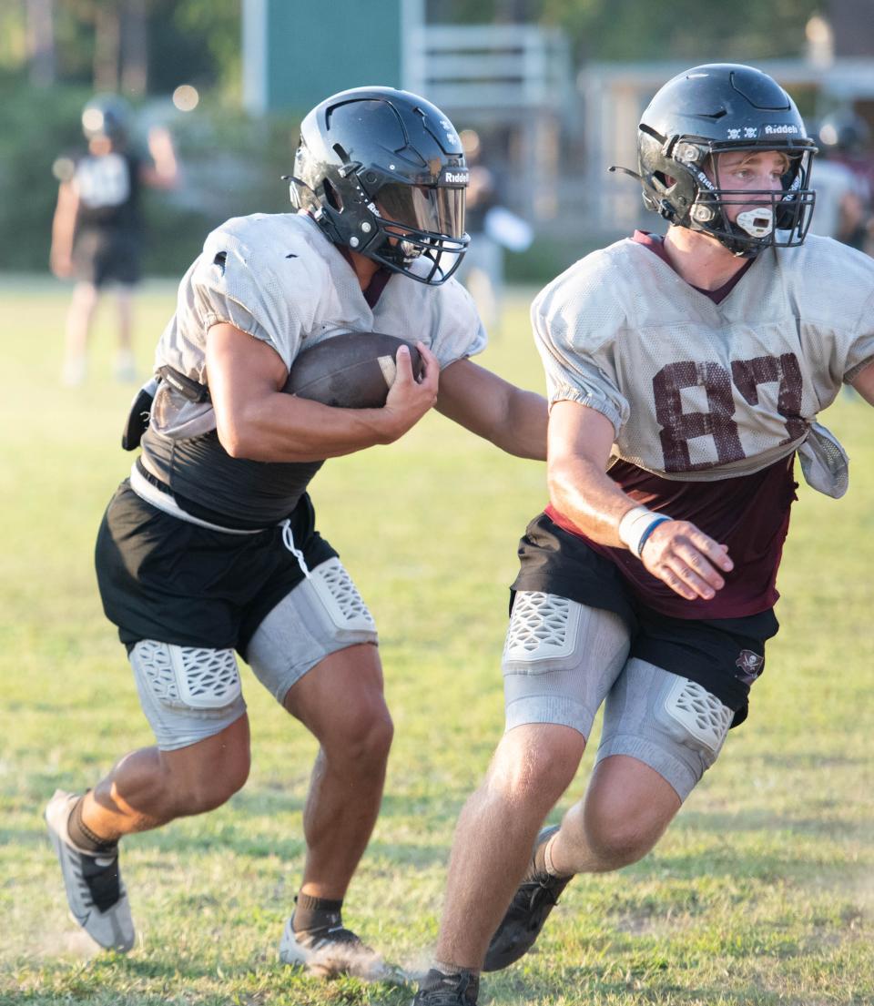 Connor Mathews (28) carries the ball during football practice at Navarre High School on Wednesday, Aug. 2, 2023.