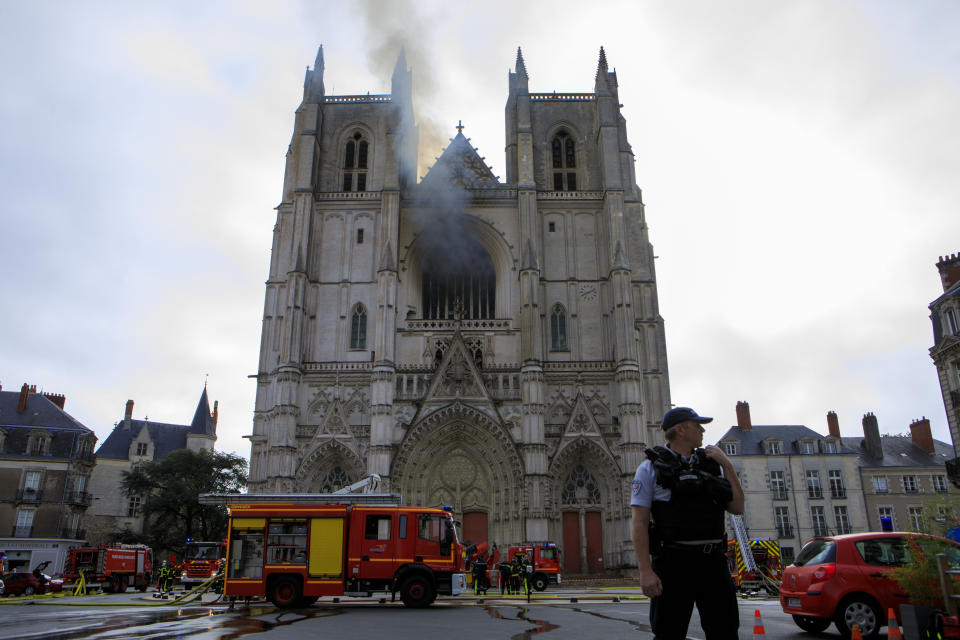 Fire fighters brigade work to extinguish the blaze at the Gothic St. Peter and St. Paul Cathedral, in Nantes, western France, Saturday, July 18, 2020. The fire broke, shattering stained glass windows and sending black smoke spewing from between its two towers of the 15th century, which also suffered a serious fire in 1972. The fire is bringing back memories of the devastating blaze in Notre Dame Cathedral in Paris last year that destroyed its roof and collapsed its spire and threatened to topple the medieval monument. (AP Photo/Laetitia Notarianni)