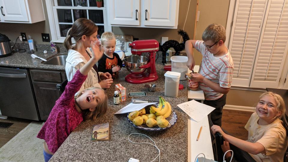 Elliott Stay works on his cookies with his mother, two younger sisters and his younger brother.