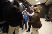 Chicago resident Ray Mandel, center, shows his target to others during a shooting session at Maxon Shooter's Supplies and Indoor Range, Friday, April 30, 2021, in Des Plaines, Ill. After a year of pandemic lockdowns, mass shootings are back, but the guns never went away. As the U.S. inches toward a post-pandemic future, guns are arguably more present in the American psyche and more deeply embedded in American discourse than ever before. The past year's anxiety and loss fueled a rise in gun ownership across political and socio-economic lines. (AP Photo/Shafkat Anowar)