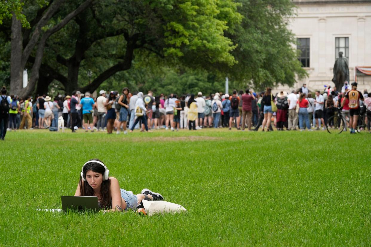 A University of Texas student studies on the South Mall while a pro-Palestinian protest continues behind her at the UT, Sunday May 5. (Credit: Jay Janner/American-Statesman)
