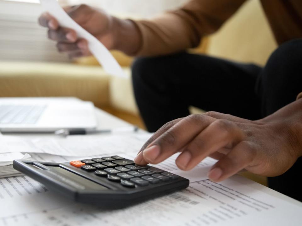 Close up of african american man with calculator checking bills